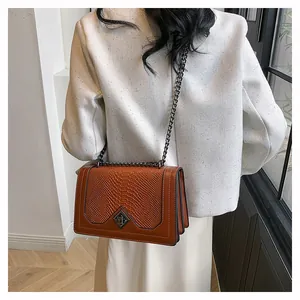 Sac bandoulière marron en cuir crocodile avec fermoir métallique et chaîne dorée