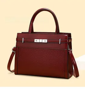Detail view of burgundy tote bag with faux crocodile pattern and silver metal buckle