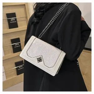 Vue détaillée d'un sac à bandoulière blanc en similicuir à texture écailles et chaîne argent