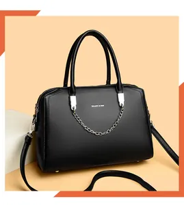 Detail of black pebbled leather tote featuring silver chain and Balado & Bag logo branding