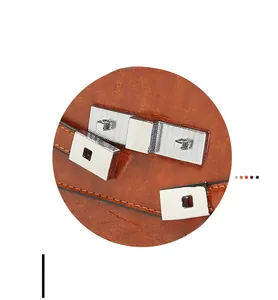 Detail of silver metal twist lock and textured brown leather on designer handbag