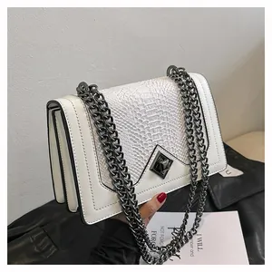 Détail du sac à main blanc avec texture peau de serpent et bandoulière chaîne noire