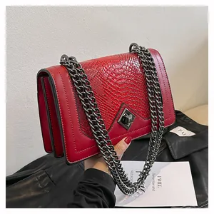Détail de la texture écailles de poisson rouge et bandoulière chaîne du sac urbain chic