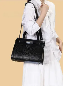 Close-up of black embossed faux leather texture with silver clasp on handbag
