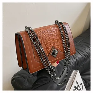 Gros plan du sac à bandoulière marron rétro avec texture serpent et fermoir en métal