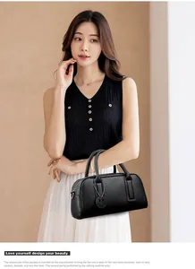 Close-up of black litchi pattern leather tote bag with smiley charm on female model