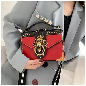 Detailed close-up of a vintage red crossbody bag with golden lion head buckle and rivets