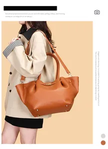 Orangefarbene Shopper-Tasche aus Leder mit langem Riemen, getragen von einem Model