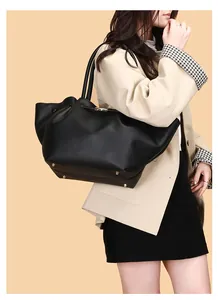 Detailaufnahme der schwarzen Shopper-Tasche mit Lederkörnung und goldenen Standfüßen