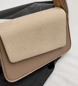 Detailed view of beige crossbody bag showing woven texture and smooth leather finish