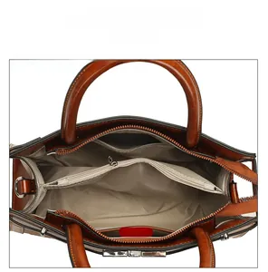 Internal view of brown vintage handbag showing spacious main compartments and zippers