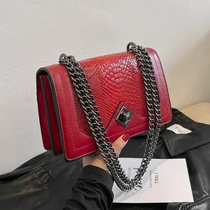 Sac bandoulière rouge avec texture d'écailles de poisson et bandoulière chaîne noire