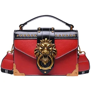 Vintage red leather crossbody bag with golden lion head buckle and studded details
