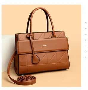 Macro view of brown leather bag showing geometric quilted texture and silver logo detail