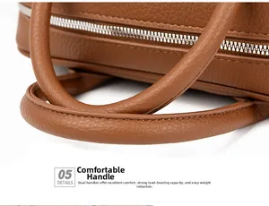 Detail of brown litchi pattern leather boston bag with silver metal zipper and handles