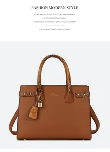 Dettaglio borsa tote in pelle caramello con trama litchi e lucchetto dorato decorativo