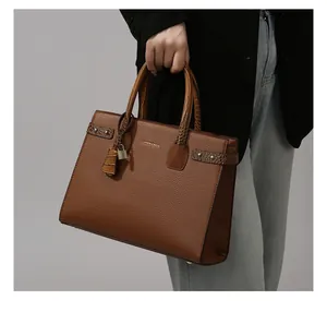 Dettaglio della borsa tote marrone caramello con texture a coccodrillo e dettagli dorati
