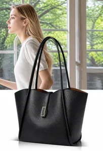 Close-up of black litchi grain leather tote bag with elegant gold metal buckle