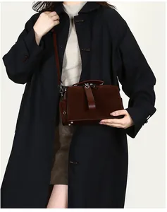 Detailstruktur der dunkelbraunen Boston Bag aus Wildleder mit Ledergriff und Metallringen