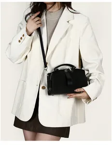 Modell mit schwarzer matten Boston-Tasche mit Henkeln und schmalem Schultergurt