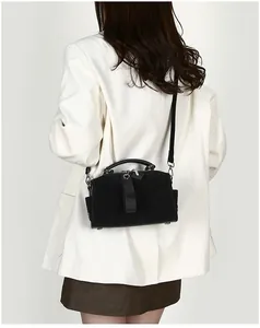 Model trägt schwarze Boston-Tasche aus Wildleder mit Ledergriffen und Metallkette