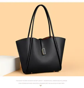 Close-up of black leather bucket bag with pebble texture and gold metal feet detailing