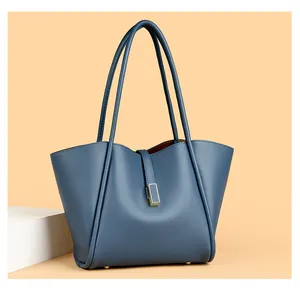 Detail of blue tote bag showing lychee pattern leather and gold metal buckle