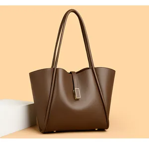 Detail of lychee pattern brown leather bucket bag with golden buckle and sturdy rivets