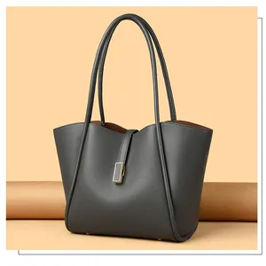 Close-up of gray pebble leather tote bag with gold metal lock and long handles