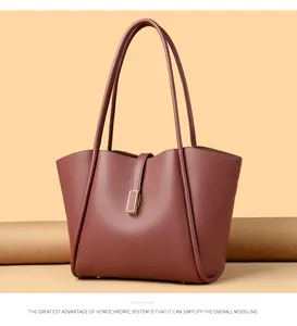 Detail shot of brick red tote bag with lychee texture and metallic buckles