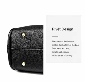 Detail of high-quality black pebble leather bucket bag with protective gold bottom rivets
