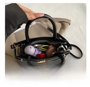 Internal capacity of black crossbody bag showing space for umbrella and cosmetics