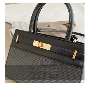 Detailed close-up of golden metal turn-lock and premium leather texture on a stylish handbag