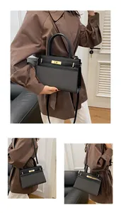 Detail of black fabric拼接 leather handbag with golden twist lock and detachable strap