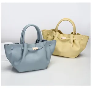 Detailed view of large tote bags in sky blue and light yellow with pebble leather texture