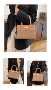 Detail of camel leather handbag showing gold twist lock and woven texture detail