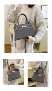 Three-way view of a grey patchwork handbag with a gold twist lock and crossbody strap