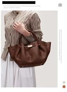Detail of dark brown pebble leather tote bag with gold hardware shown on a model