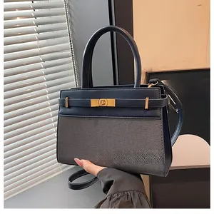 Close-up of blue leather and grey fabric handbag with golden twist lock and strap