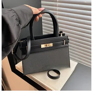 Detail of a chic black leather and mesh handbag with golden twist lock on vintage books