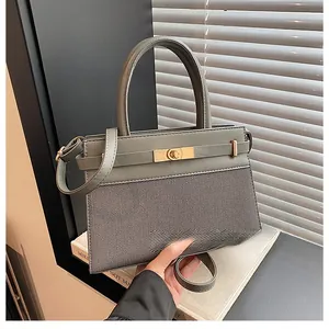 Detail of grey-green leather handbag with gold twist lock and woven texture panels