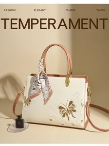 Détails de broderie florale sur sac cabas blanc avec foulard en soie et finitions dorées