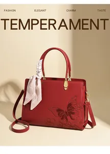 Détail du sac rouge en cuir avec gaufrage papillon et élégant foulard en soie