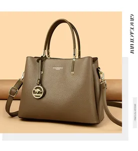 Vista detallada del bolso tote de cuero caqui con colgante de canguro y logotipo de marca