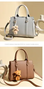 Détail de sacs cabas en cuir grainé avec pendentif ours et lettrage mode élégant