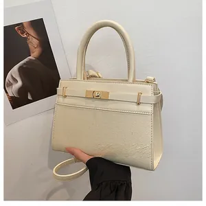 Detailed close-up of a cream crossbody bag with canvas texture and gold twist lock