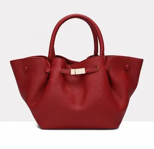 Detail of red wing tote bag featuring lychee grain texture and golden metal buckle