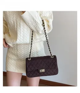 Close-up of quilted velvet texture and golden chain on a vintage crossbody bag
