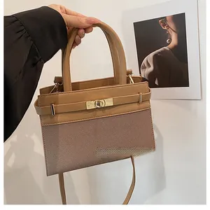Detailed side view of khaki leather patchwork handbag with gold clasp and top handle