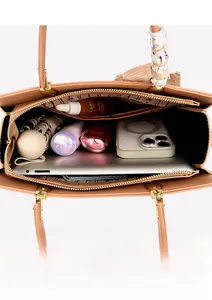 Vue intérieure montrant la grande capacité et les poches de ce sac cabas brodé beige